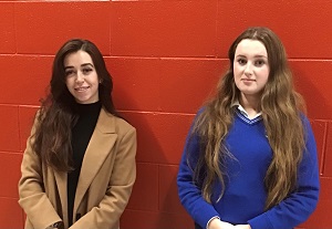 Grianghraf de scoláire agus múinteoir os comhair balla dearg