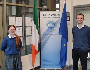 Grianghraf de scoláire agus múinteoir le bratacha na hÉireann agus an Aontais Eorpaigh